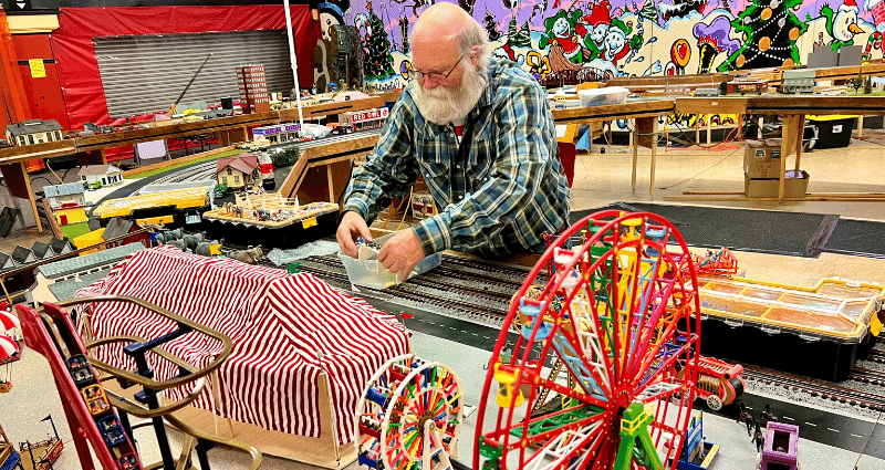 A man sets up a model train display