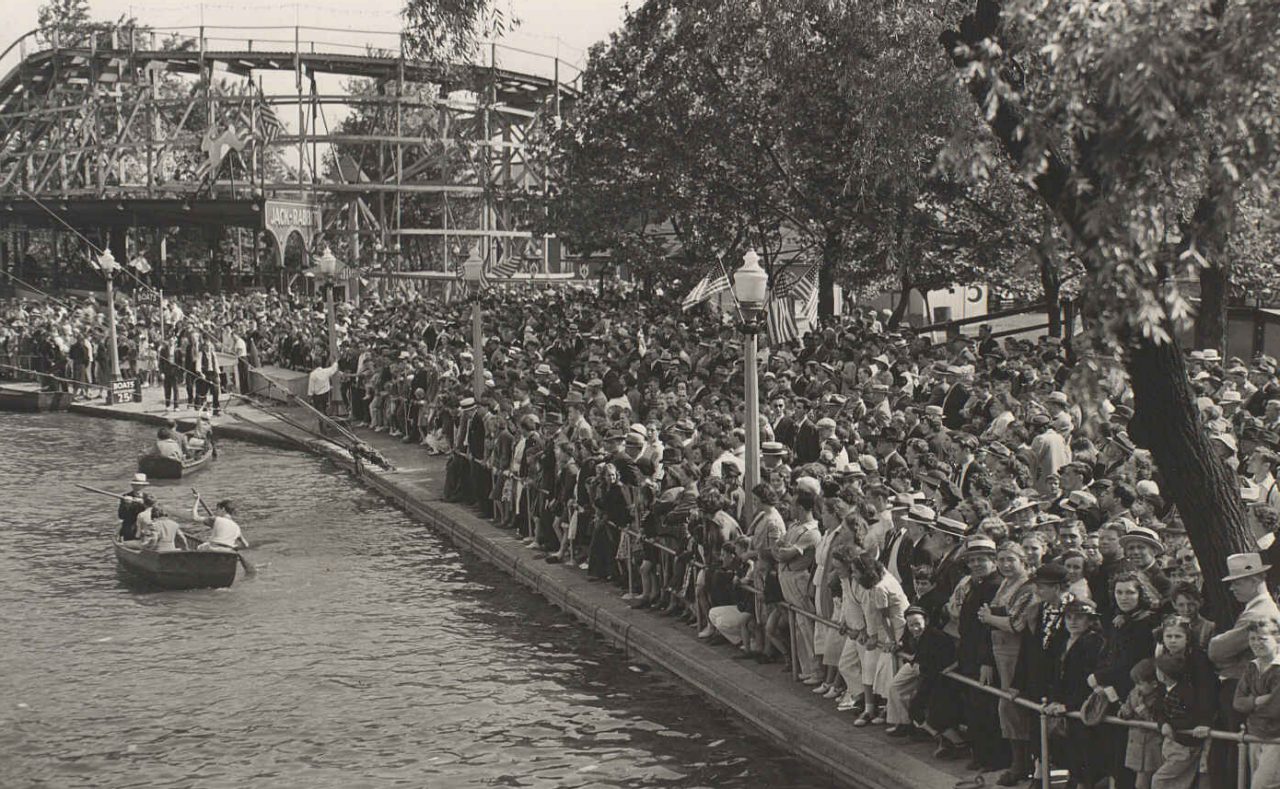 A packed post-World War II Kennywood near the Lagoon. Jack Rabbit in the background with American flags on the lights.