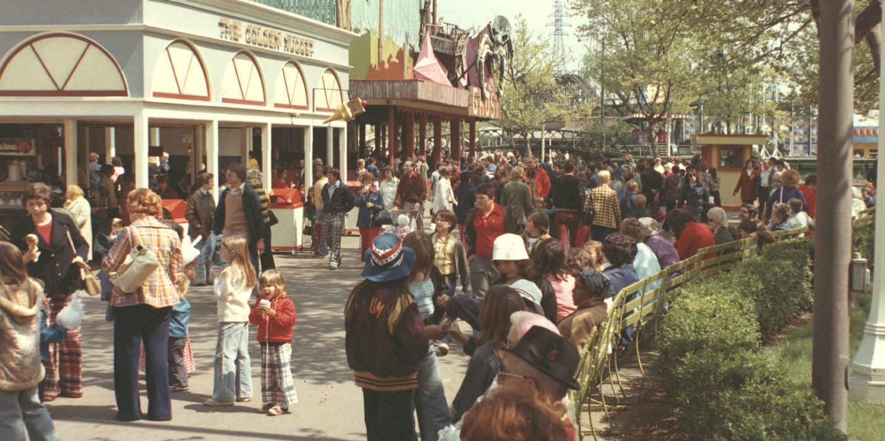 Guests enjoy chocolate dip cones from the Golden Nugget in the 1970s. The Ghost Ship dark ride can be seen in the background.